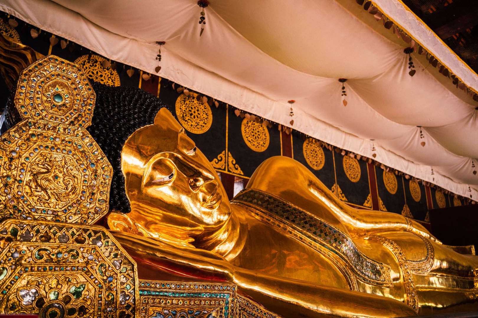 Eine goldene Statue eines liegenden Buddhas in einem Tempel