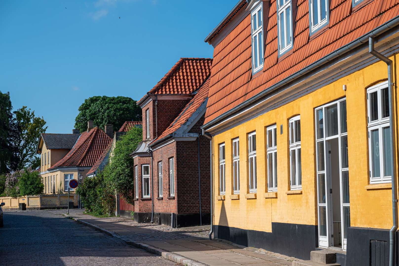 Eine Reihe von Häusern mit roten Dächern und gelben Fassaden