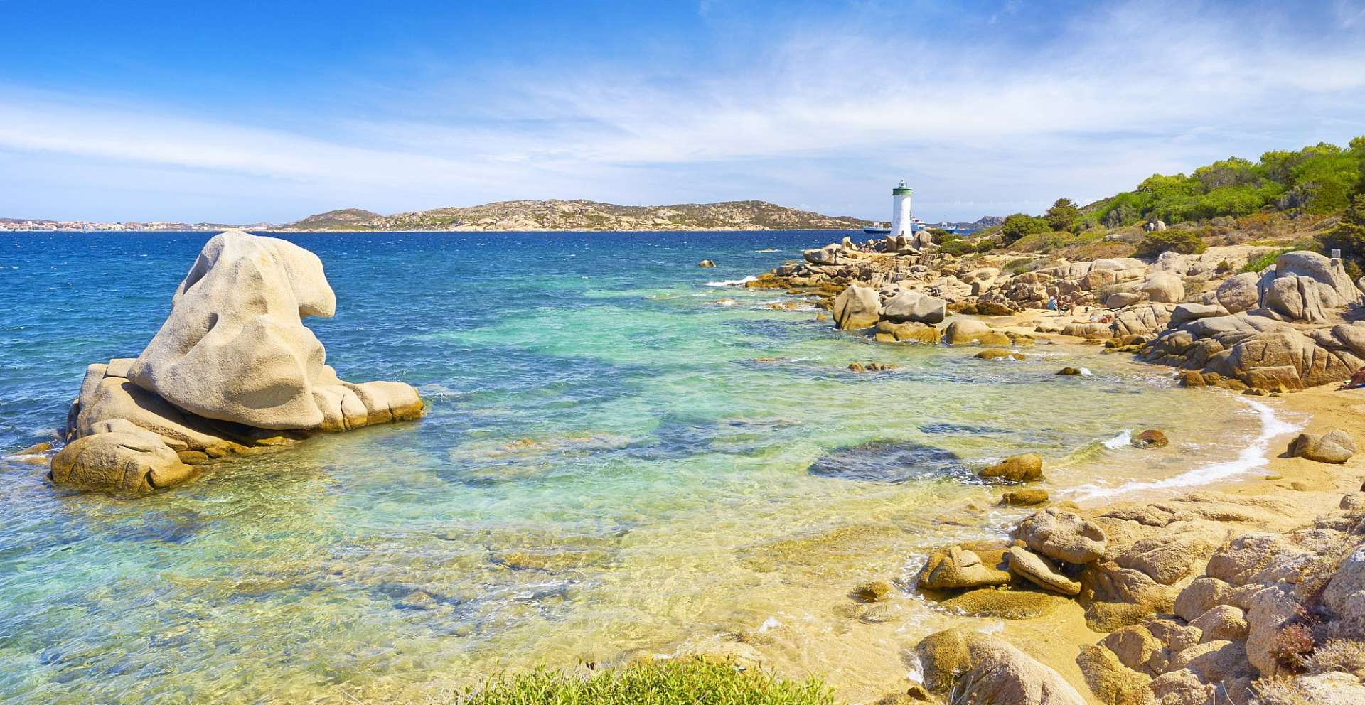 Ein Leuchtturm steht an einem felsigen Strand