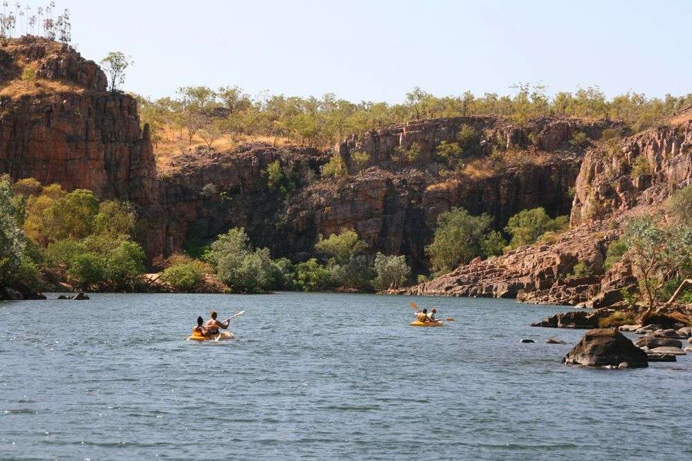 Menschen paddeln in einem See mit Felsen im Hintergrund
