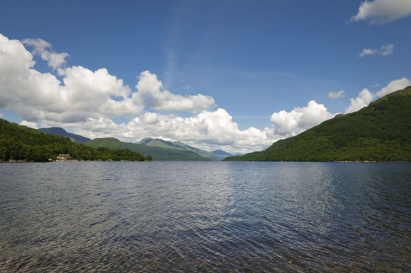 Ein See mit Bergen im Hintergrund an einem sonnigen Tag
