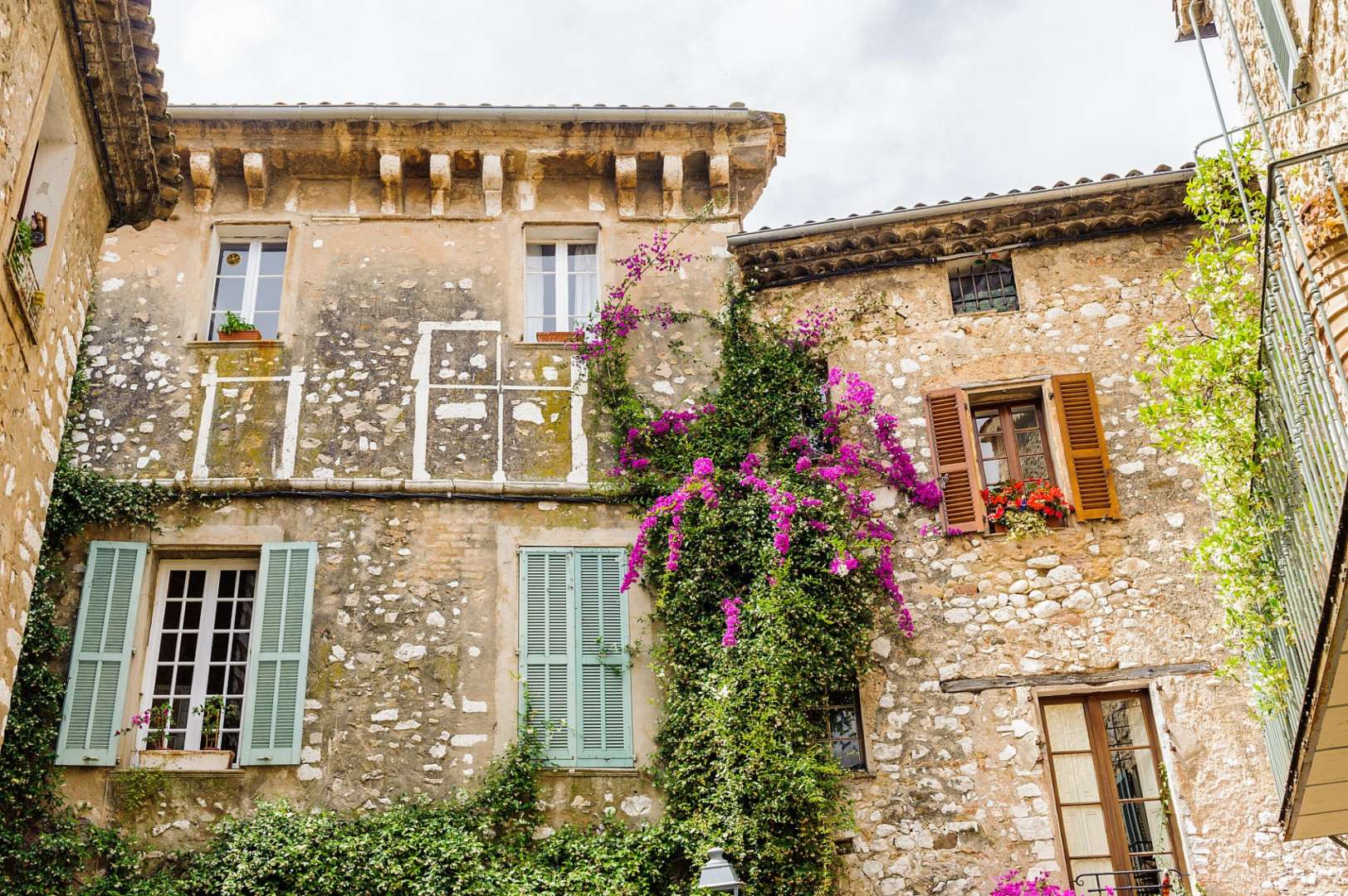 Ein Gebäude mit lila Blumen und blauen Fensterläden