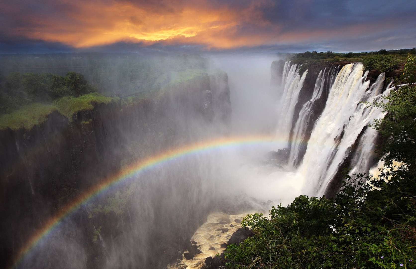 Ein Wasserfall mit einem Regenbogen in der Mitte