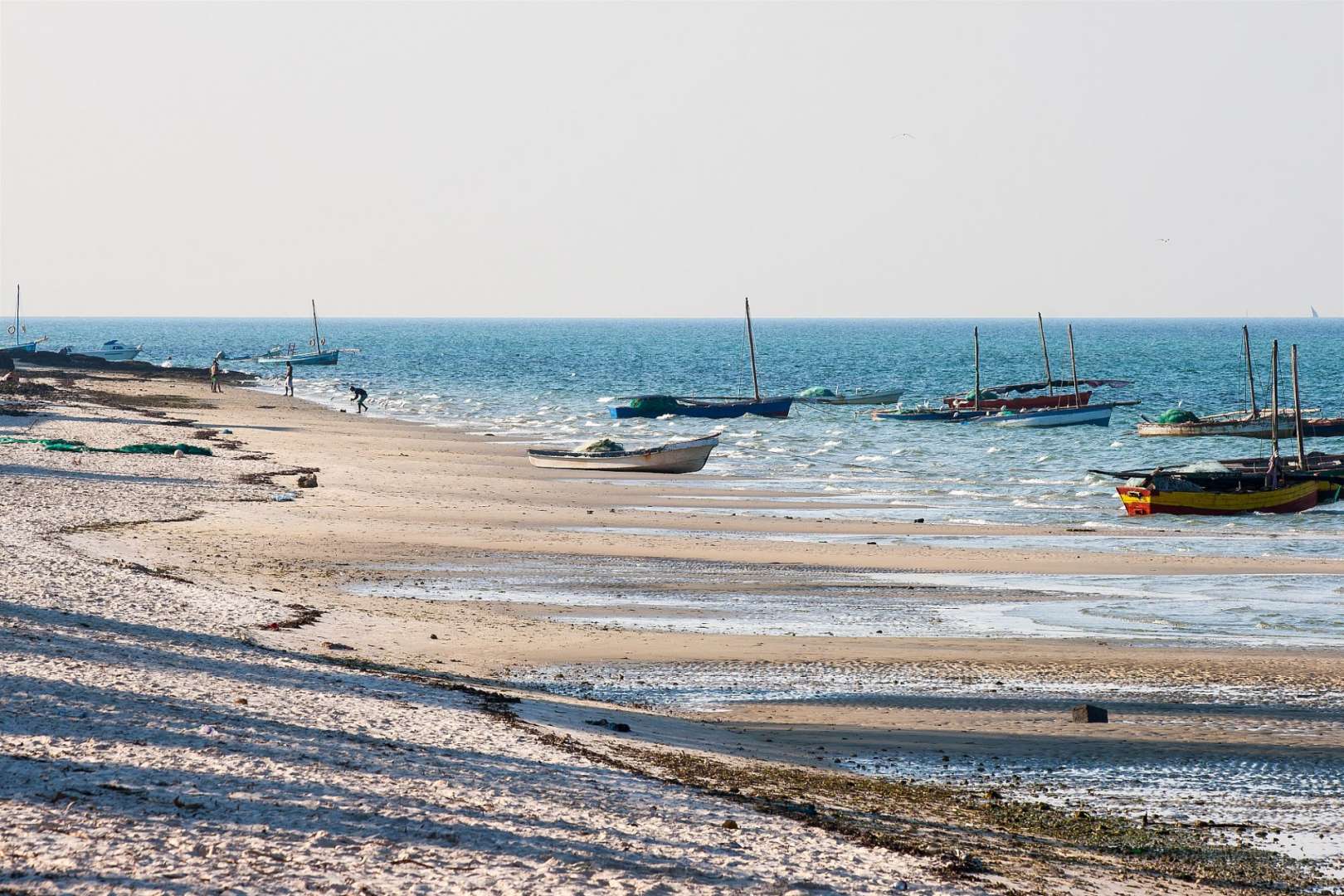 Ein Strand mit vielen Booten im Wasser