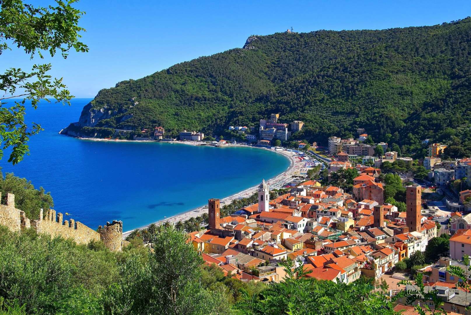 Eine Stadt mit roten Dächern und einem blauen Ozean dahinter