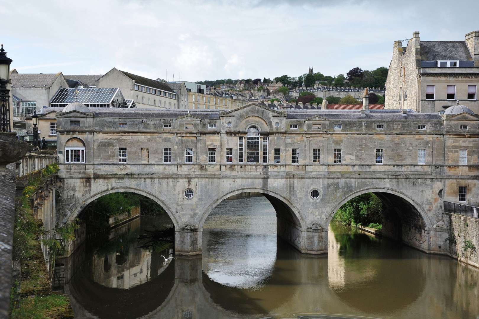 Eine Brücke über einen Fluss mit einem Gebäude im Hintergrund