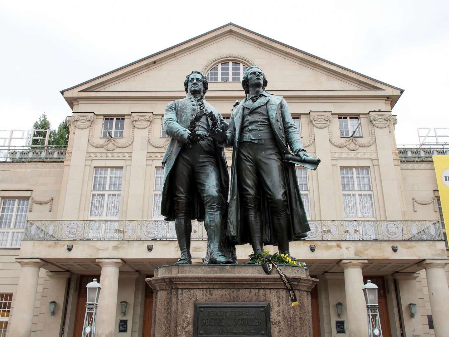 Eine Statue von goethe und schiller vor einem Gebäude