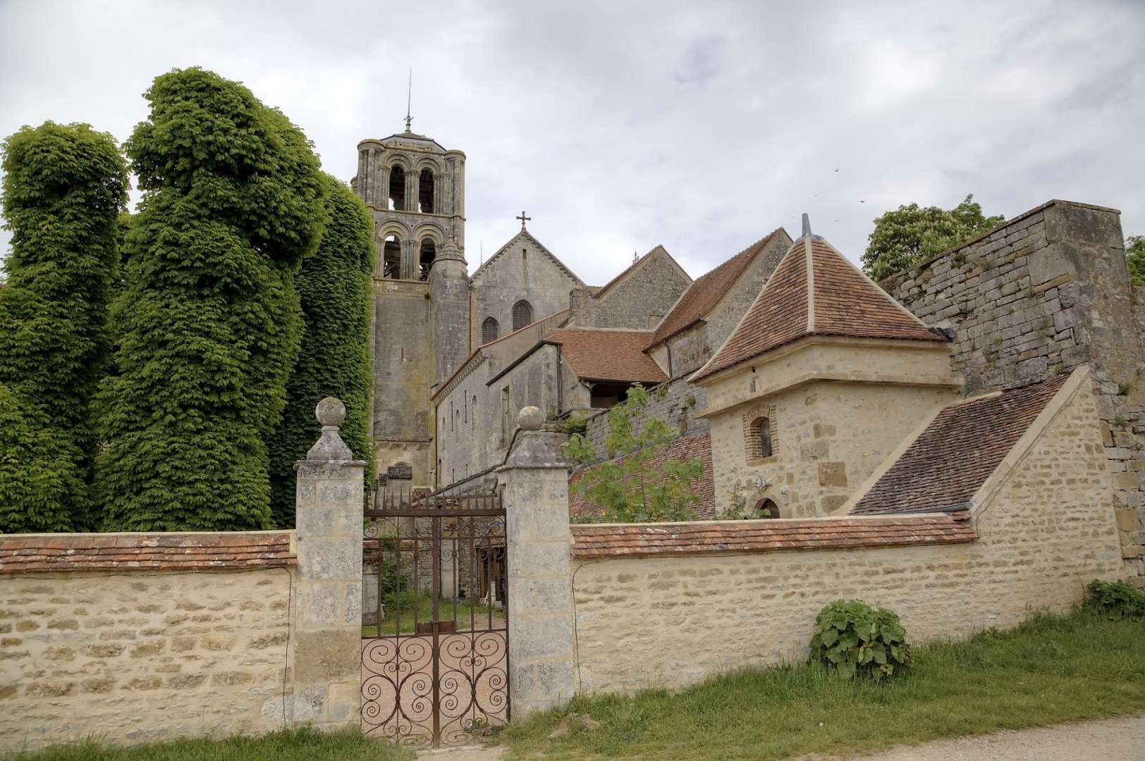 Eine Kirche mit einem Glockenturm steht hinter einer Steinmauer