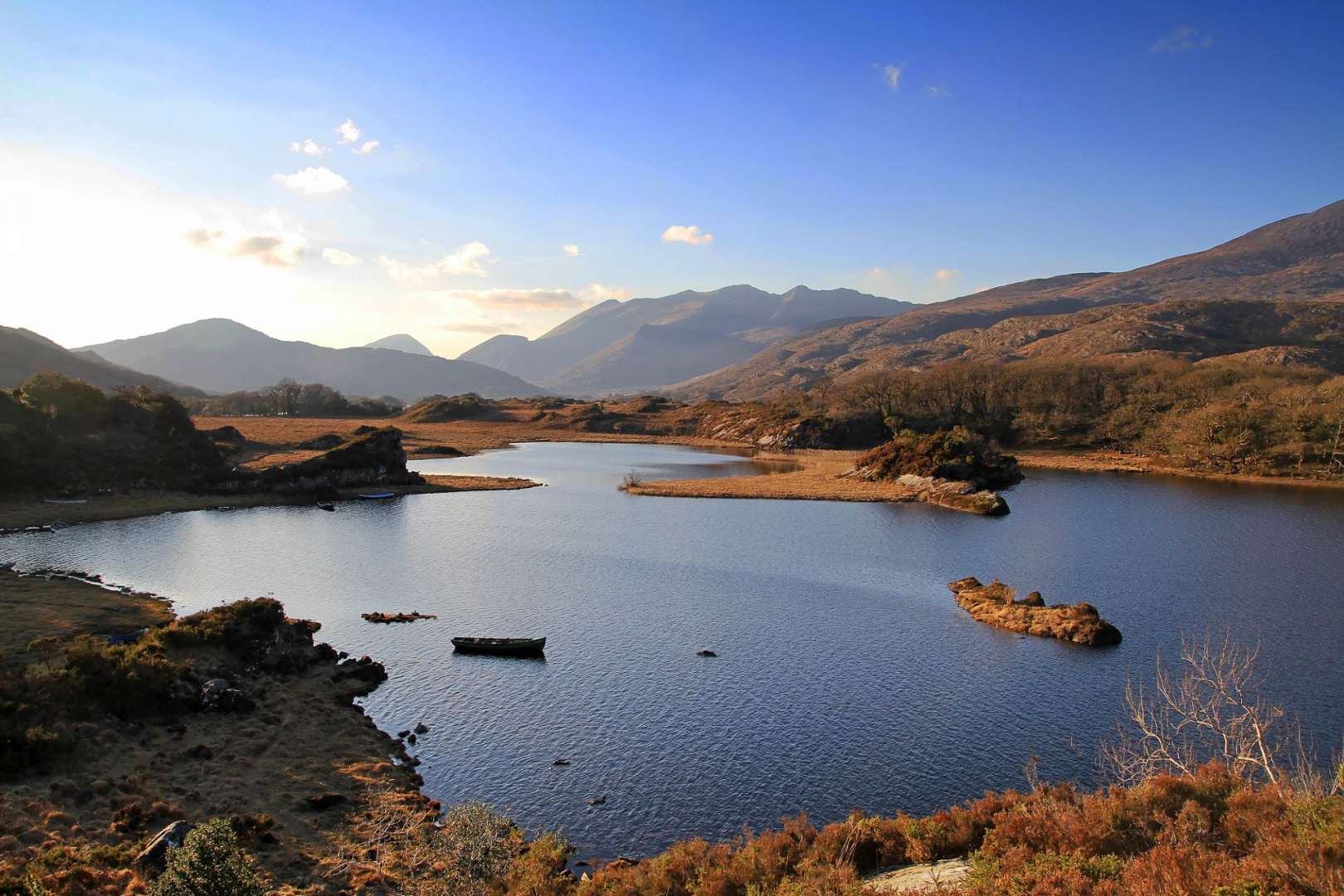 Ein See mit kleinen Inseln und Bergen im Hintergrund