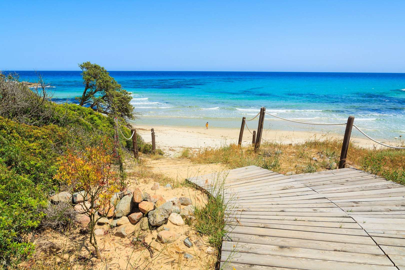 Eine Holztreppe führt hinunter zu einem Strand