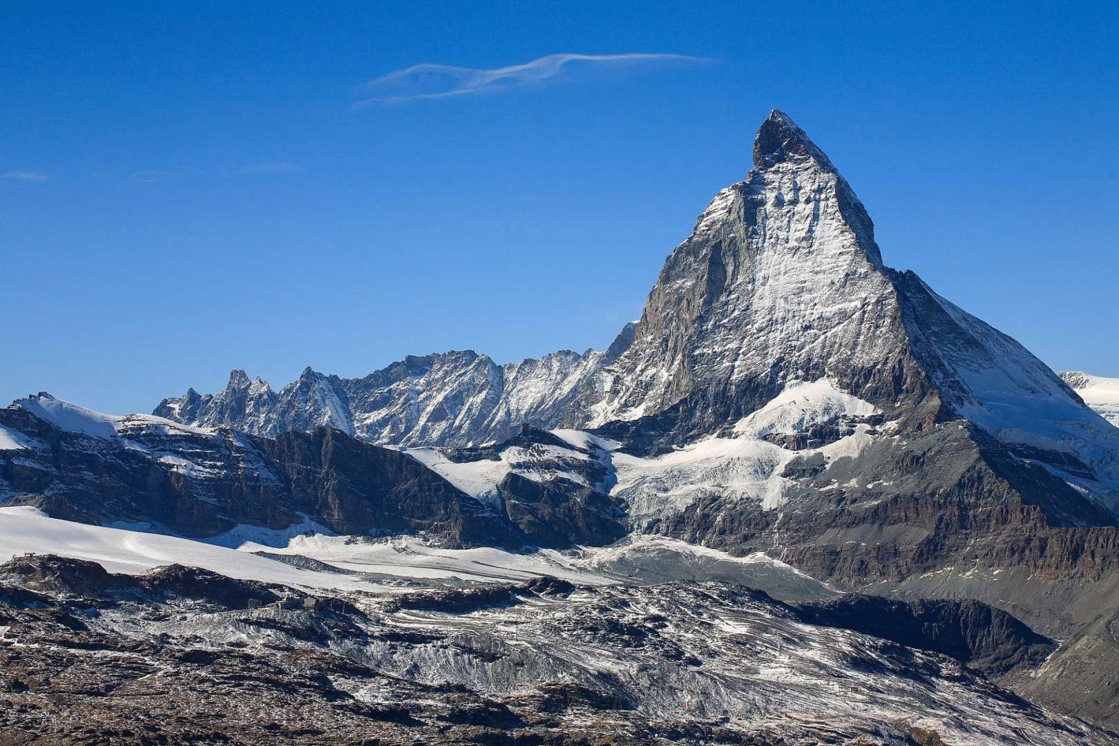 Ein schneebedeckter Berg mit einem blauen Himmel im Hintergrund
