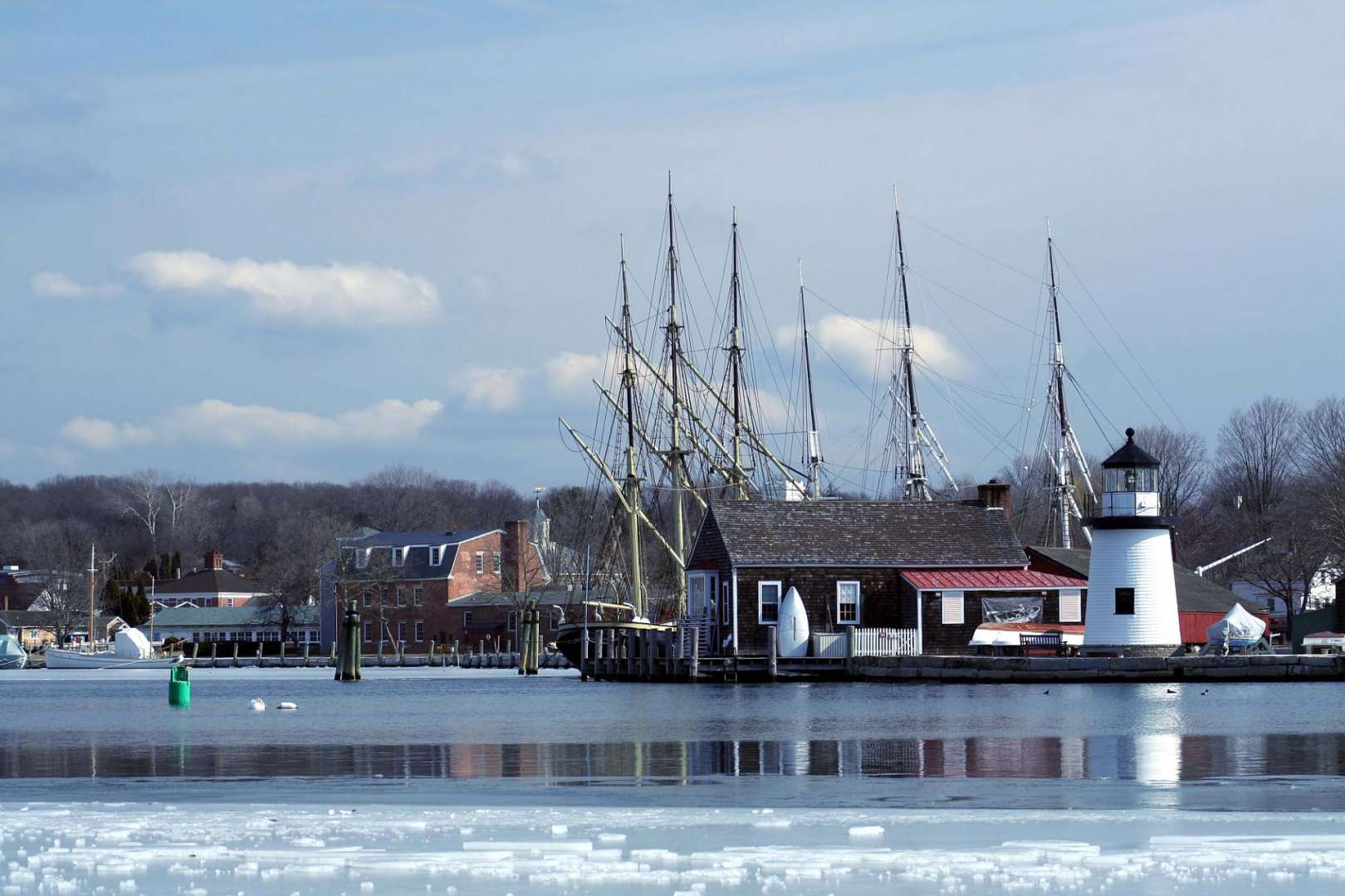 Ein Leuchtturm steht neben einem Gebäude in einem Hafen