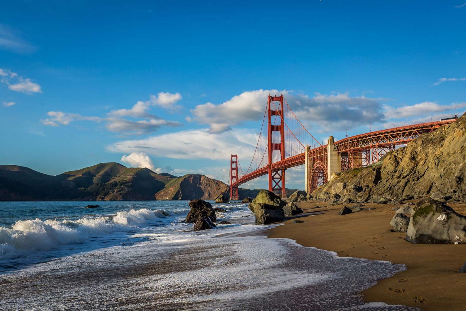 Die golden gate bridge hängt über einem sandigen strand