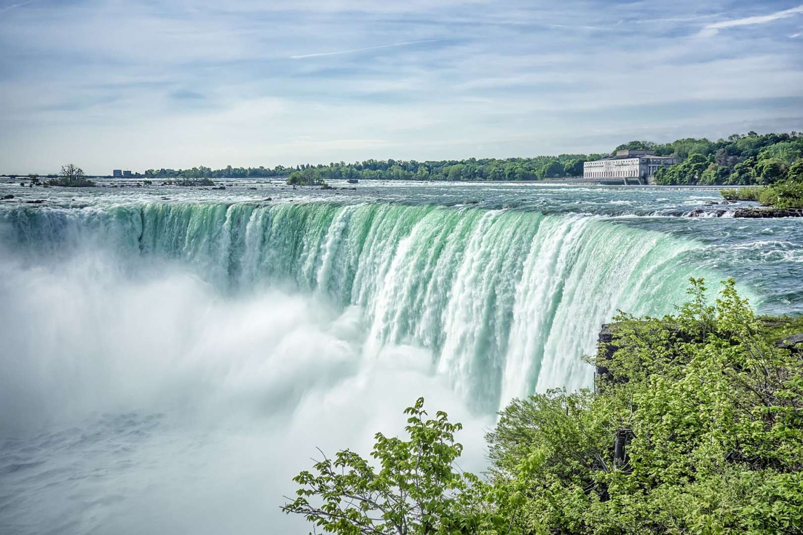 Ein Wasserfall mit einem Gebäude im Hintergrund