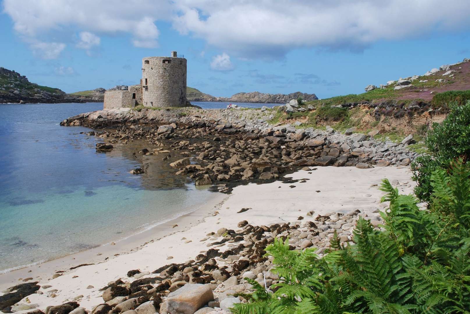 Ein kleiner Strand mit einem Turm im Hintergrund