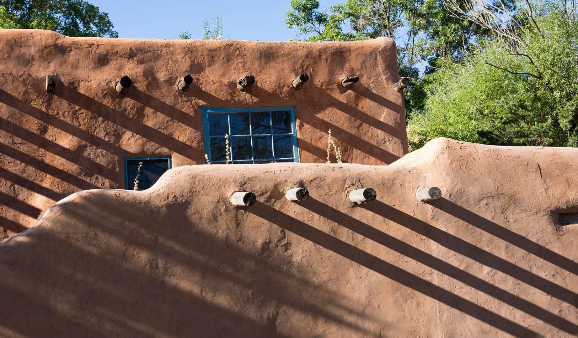 Ein Adobe-Haus mit einem blauen Fenster