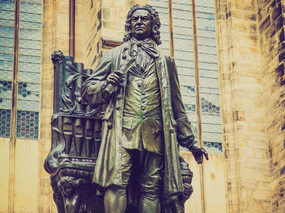 Eine Statue eines Mannes, der vor einem Gebäude sitzt