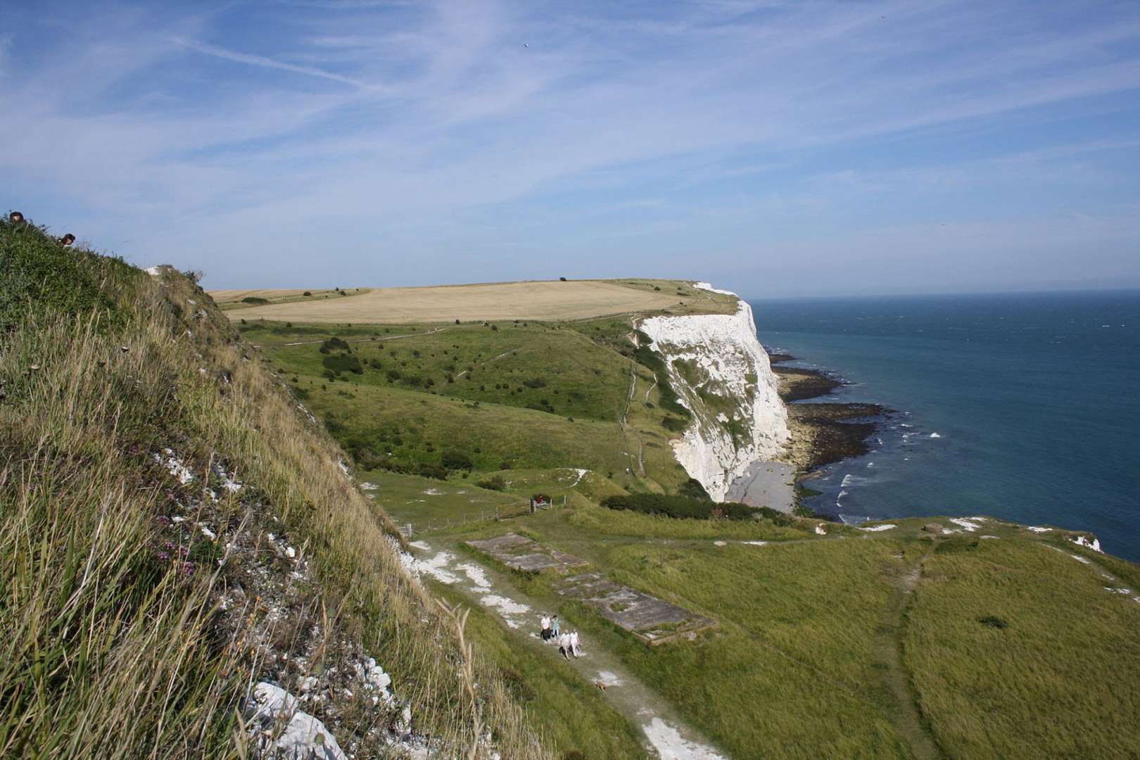 Eine Gruppe von Menschen steht auf einer Klippe mit Blick auf das Meer