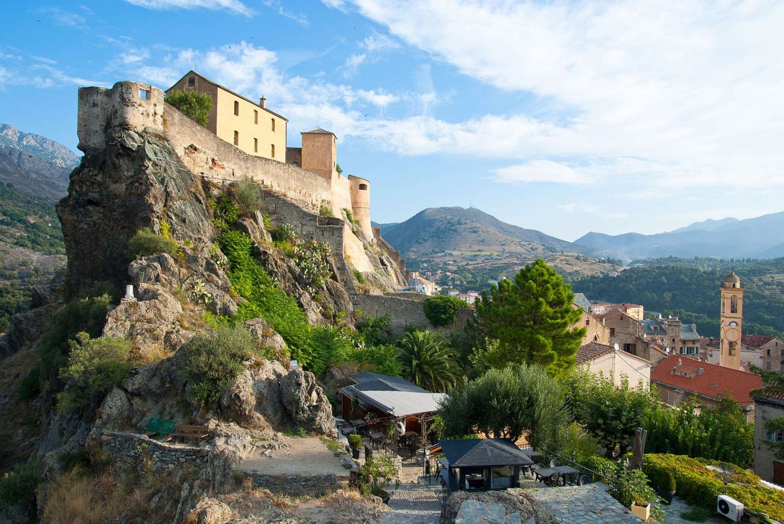 Ein Gebäude steht auf einem Felsen mit Blick auf eine Stadt