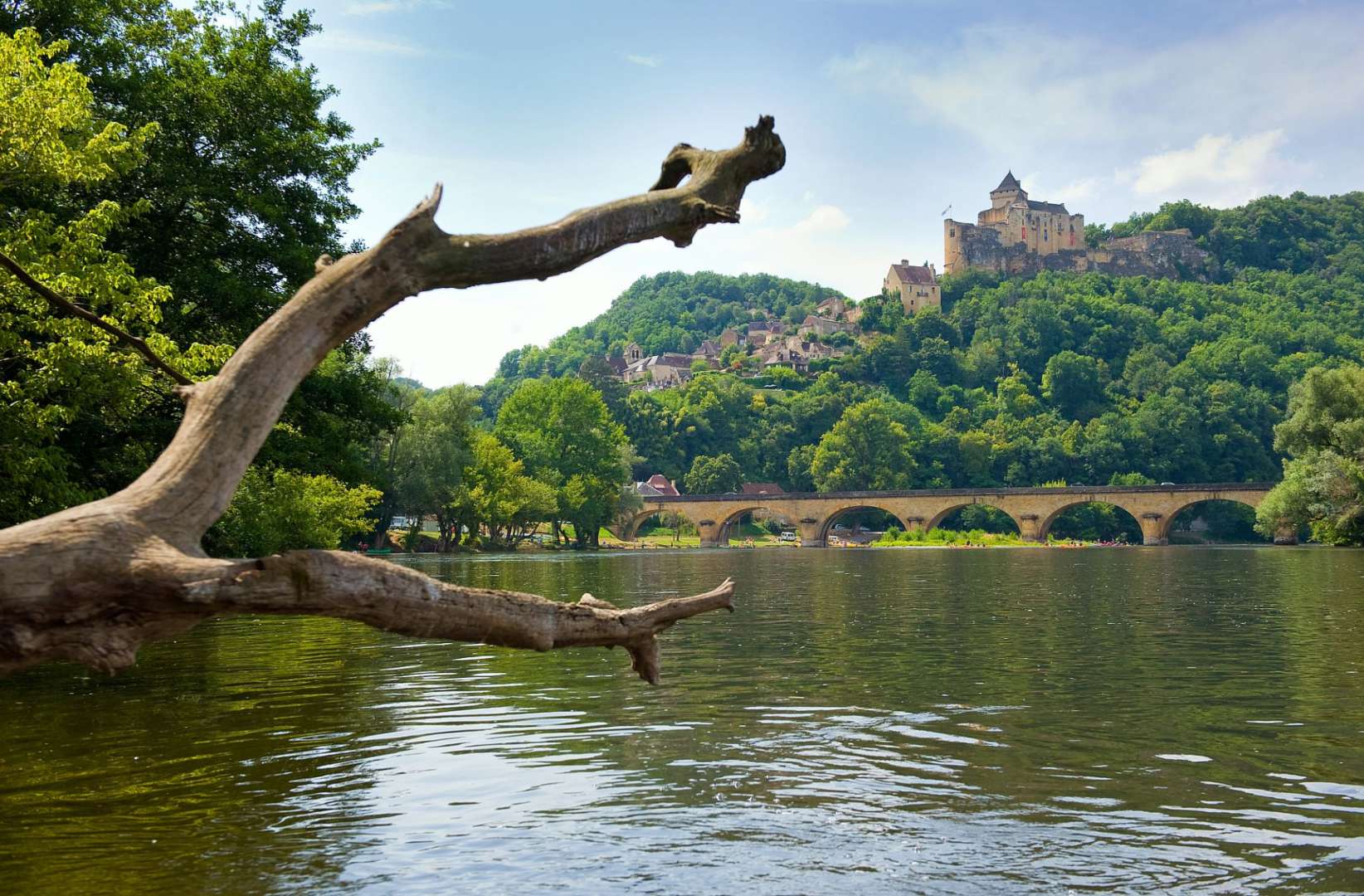 Eine Brücke über einen Fluss mit einem Schloss im Hintergrund