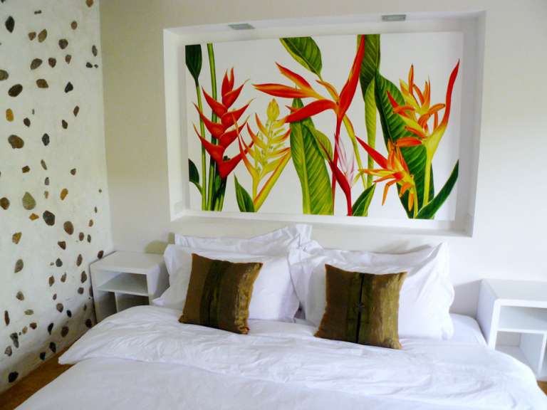 Ein Schlafzimmer mit einem Gemälde an der Wand über dem Bett
