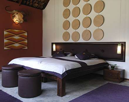 Ein Schlafzimmer mit einem Bett und zwei Hockern