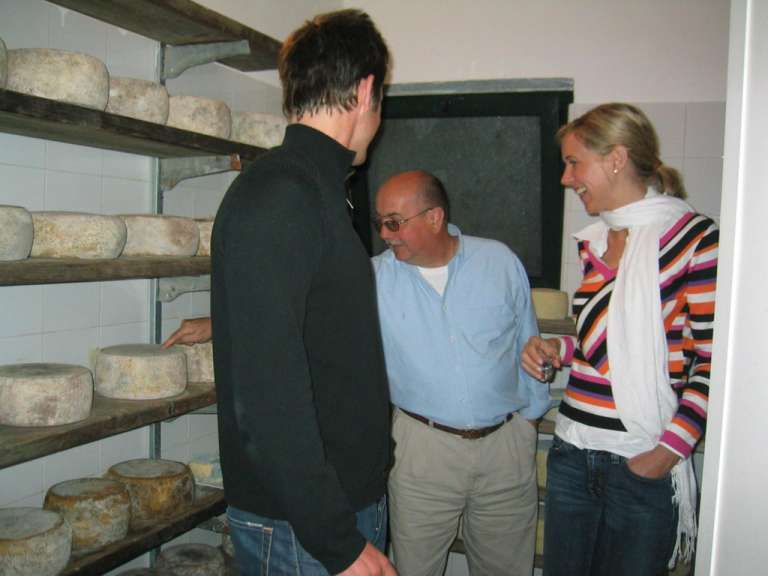 Ein Mann und eine Frau stehen neben einem Regal mit Käse