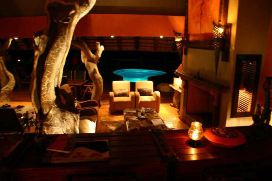 Ein Wohnzimmer mit zwei Stühlen und einem Kamin mit einem Pool im Hintergrund