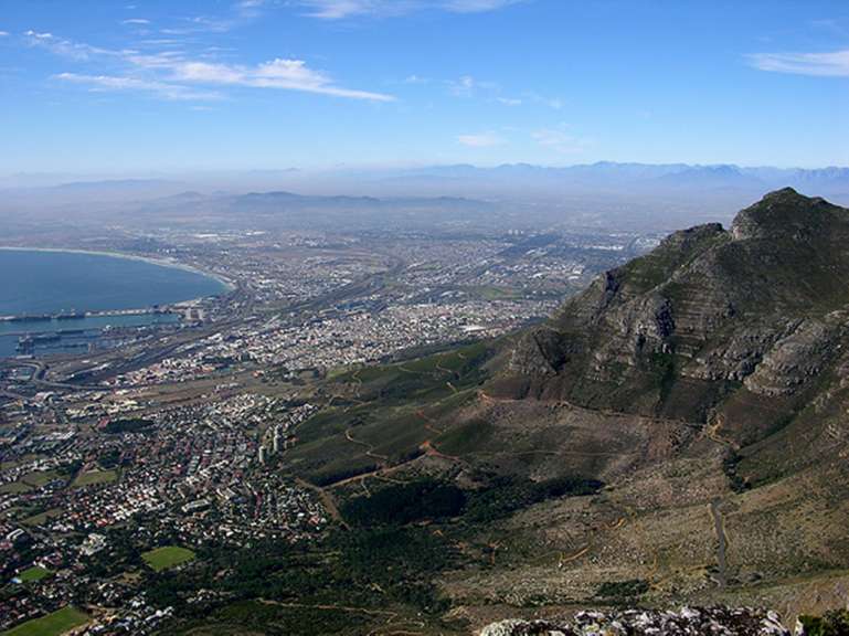 Eine Luftaufnahme einer Stadt und eines Sees mit Bergen im Hintergrund