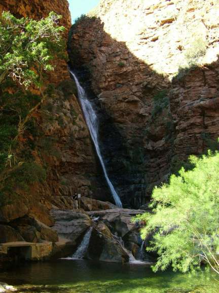 Ein Wasserfall stürzt von einer Klippe in einen Pool