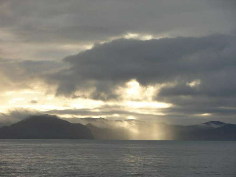 Die Sonne scheint durch die Wolken über dem Ozean