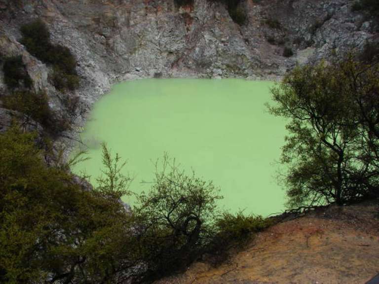 Ein grüner Teich inmitten einer Felswand
