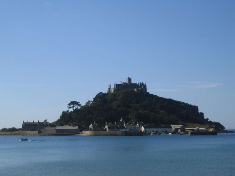 Ein großes Schloss sitzt auf einem Hügel über einem See