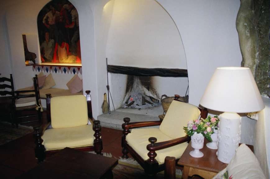 Ein Wohnzimmer mit zwei Stühlen und einer Lampe neben einem Kamin