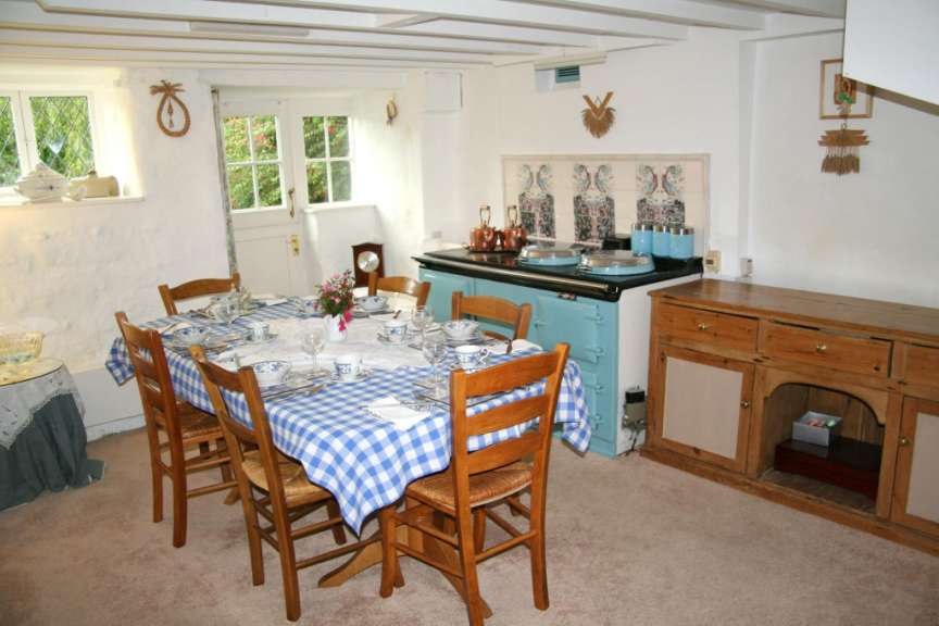 Ein Esszimmer mit einem Tisch und Stühlen und einem blauen Herd