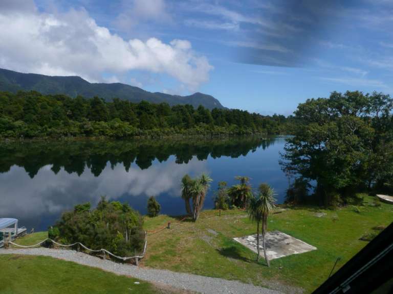 Ein See mit Bäumen und Bergen im Hintergrund
