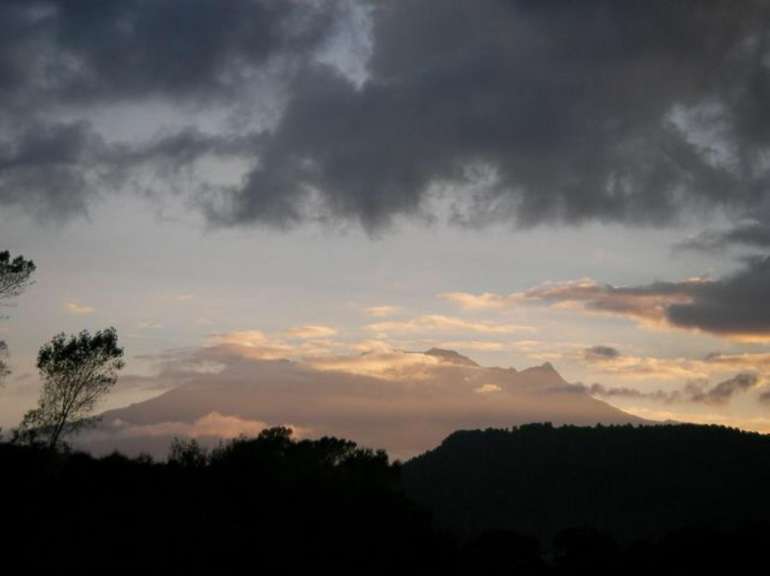 Ein bewölkter Himmel mit einem Berg im Hintergrund