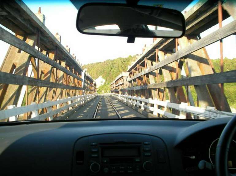 Ein Auto fährt auf einer Holzbrücke