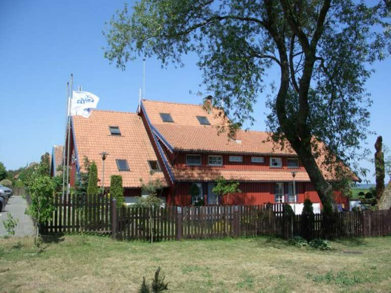 Ein rotes Haus mit einer weißen Fahne auf dem Dach, die zympa sagt