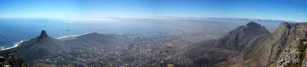 Ein Panoramablick auf eine Stadt und das Meer von der Spitze eines Berges .