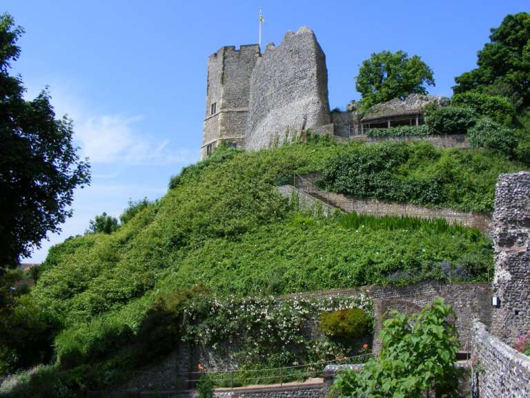 Ein Steinturm auf einem Hügel mit einer gelben Fahne darauf