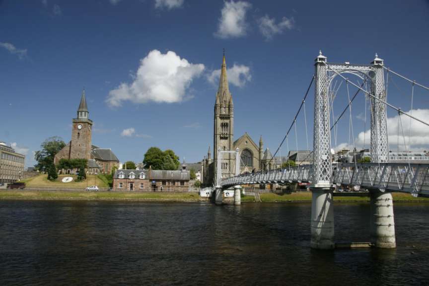 Eine Brücke über einen Fluss mit einer Kirche im Hintergrund