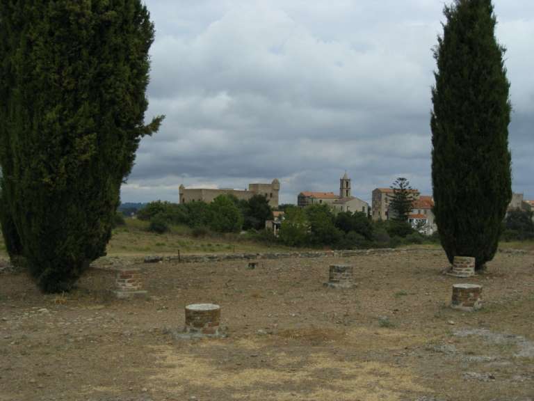 Ein Feld mit Steinsäulen und Bäumen mit einem Schloss im Hintergrund