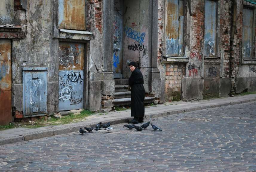 Eine Frau steht vor einem Gebäude mit Graffiti darauf