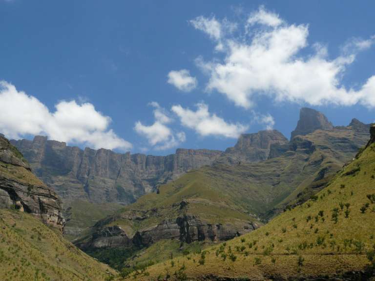 Ein Berg mit einem blauen Himmel und weißen Wolken dahinter