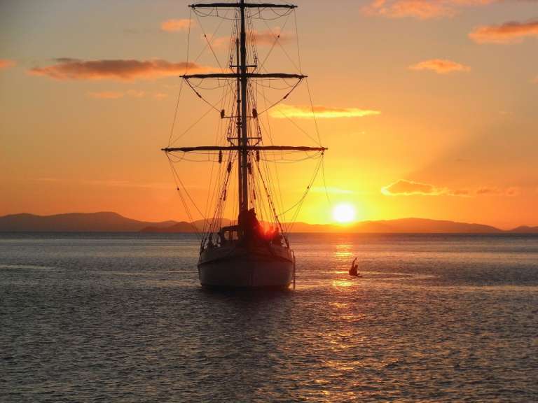 Ein Segelboot im Ozean bei Sonnenuntergang