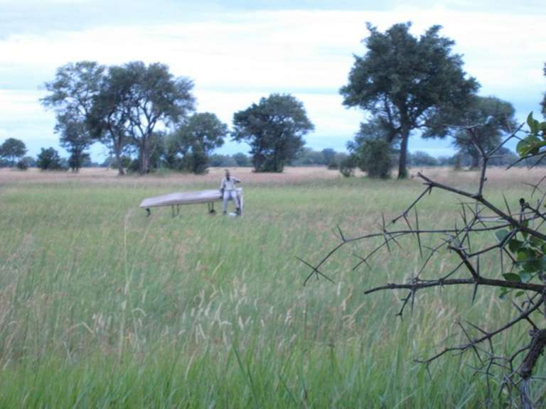 Ein Mann steht in einem Feld und hält einen Koffer