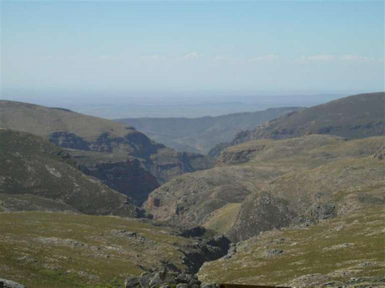 Ein Blick auf ein Tal zwischen zwei Bergen an einem sonnigen Tag