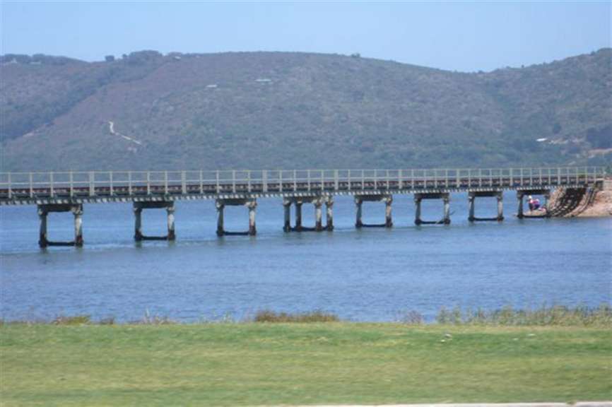 Eine Brücke über einen See mit Bäumen im Hintergrund