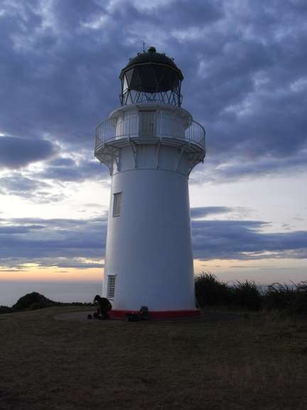 Ein weißer Leuchtturm mit einem blauen Himmel dahinter